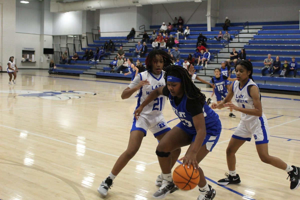 Jashia Williams, 8, and Destiny McDonald, 8, attempt to block Carrington Marks, 8, at the basketball game on February 1. At this game both of the 8th grade girls teams played against one another, the white team finishing the game victorious