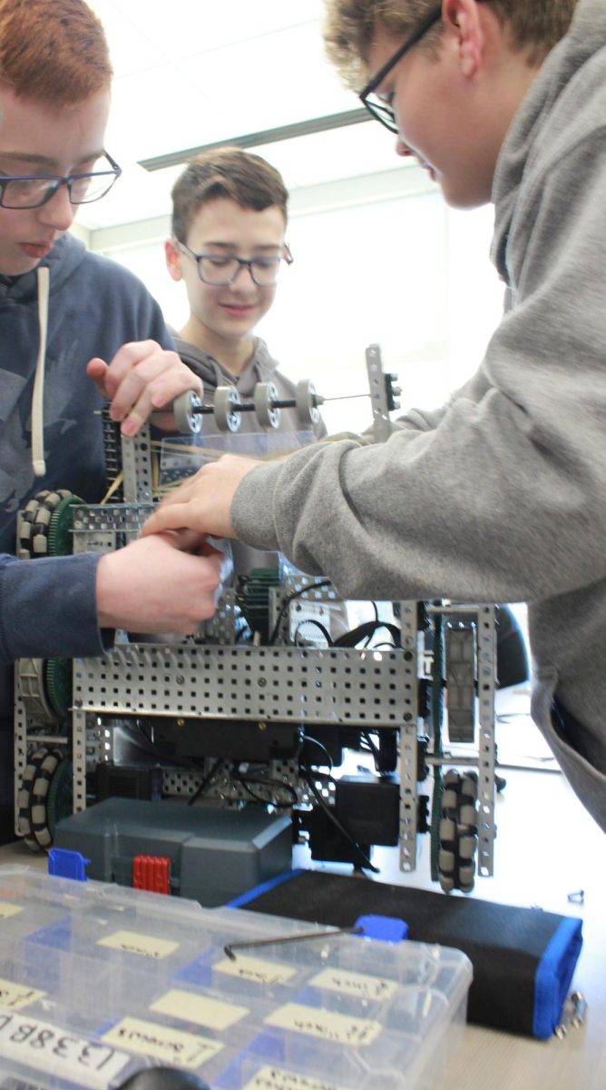 Micah Grauf, Parker Logan, Matthew Massanelli working on a robot for an in class competition.